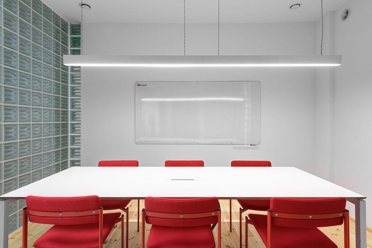 home-hero Interior of office with white table near red stools and whiteboard on wall near lamp and glass wall